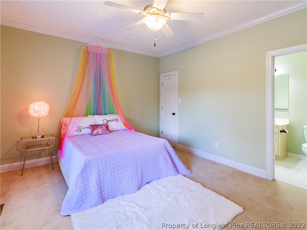 6915 Surrey Road Fayetteville, NC 28306 - Photo 6 of 37 a bedroom with a bed and a chandelier