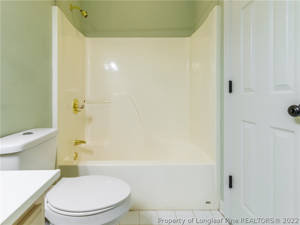 6915 Surrey Road Fayetteville, NC 28306 - Photo 7 of 37 a white toilet sitting next to a bath tub