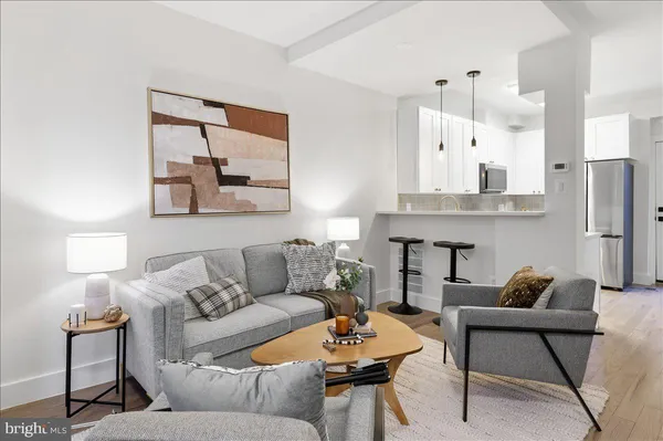 a living room with furniture and a painting on the wall