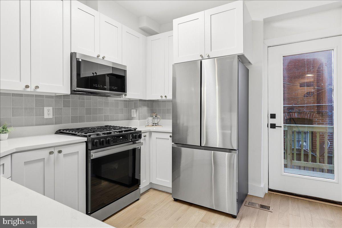 820 13th Street Northeast Washington, DC 20002 - Photo 7 of 38 a kitchen with stainless steel appliances granite countertop a refrigerator stove and microwave