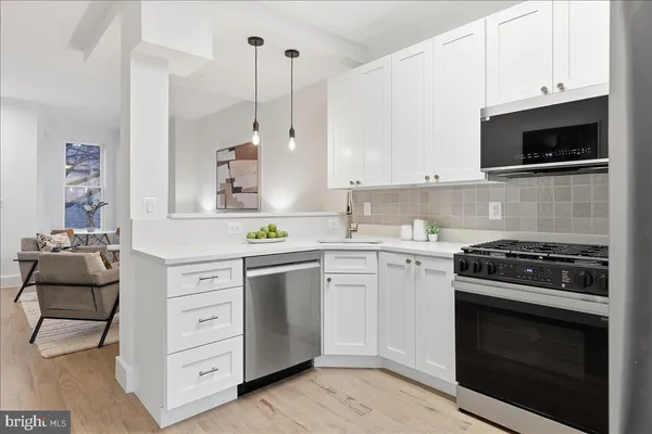 a kitchen with cabinets stainless steel appliances and wooden floor