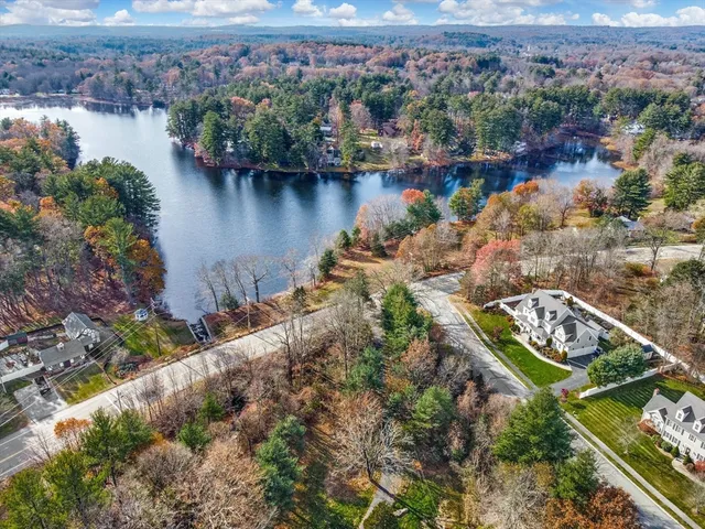 an aerial view of residential houses with outdoor space and lake view