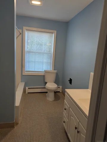 a bathroom with a sink toilet and window