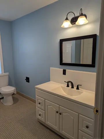 a bathroom with a toilet sink and mirror