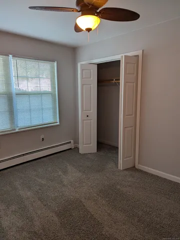 an empty room with a window and a ceiling fan