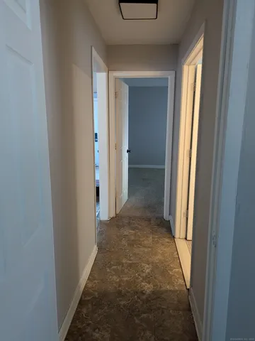 a view of a hallway with wooden shelves