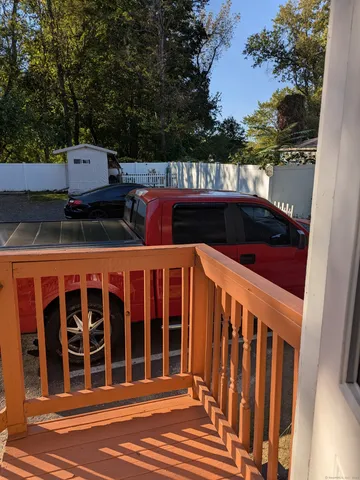 a view of a balcony with wooden floor and fence