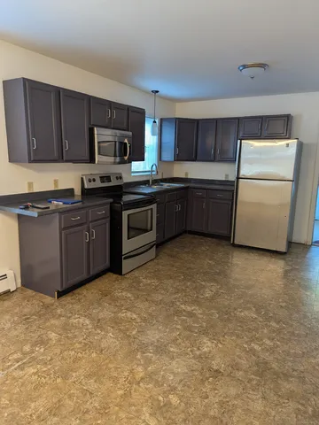 a kitchen with stainless steel appliances granite countertop a stove a sink dishwasher and a refrigerator