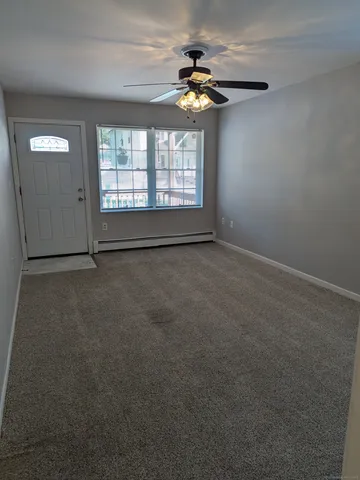 an empty room with windows and fan