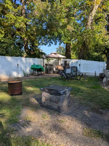 a view of a chairs and table in backyard