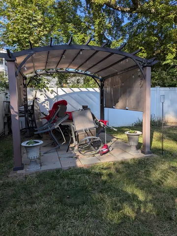 a view of a backyard with table and chairs under an umbrella