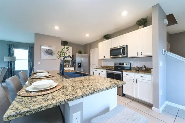 a kitchen with stainless steel appliances granite countertop a sink and cabinets