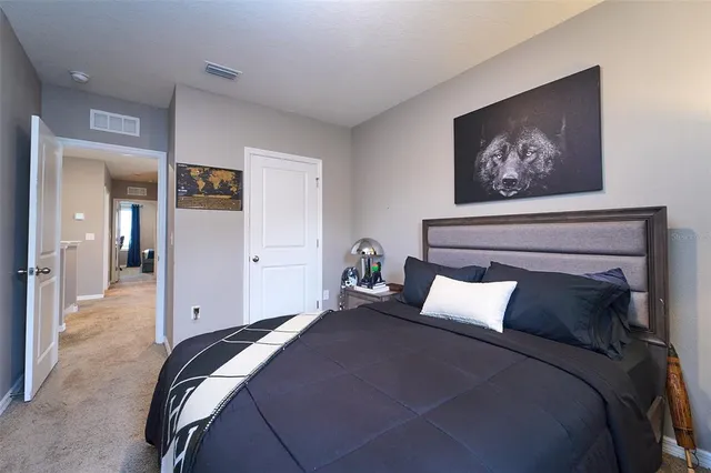 a spacious bedroom with a bed and glass window