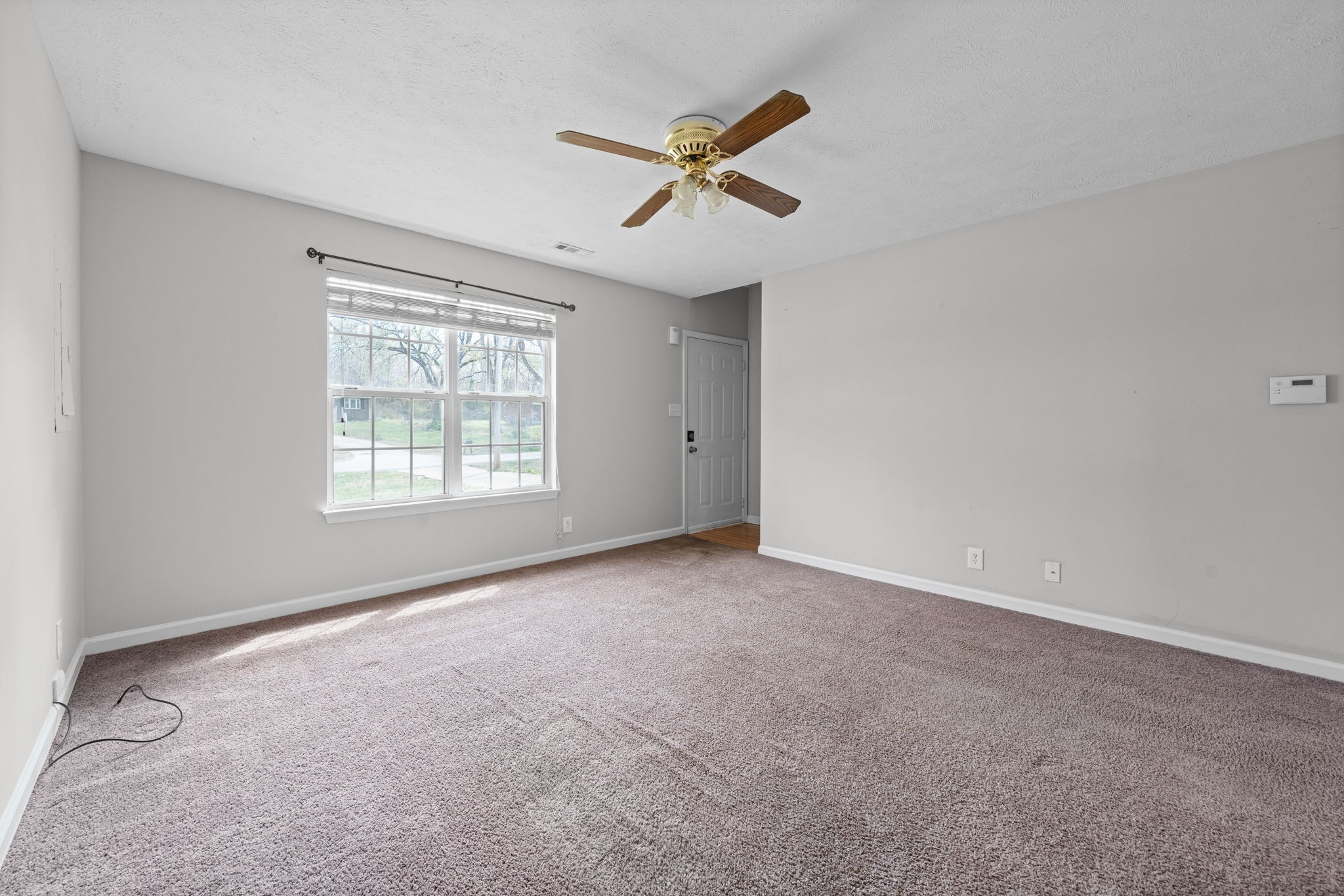 9193 Pembroke Oak Grove Road Oak Grove, KY 42262 - Photo 4 of 18 an empty room with ceiling fan and windows