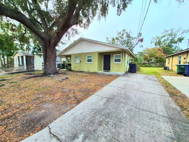a front view of a house with a yard and potted plants