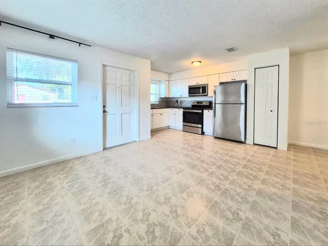 a kitchen with granite countertop a refrigerator and a sink