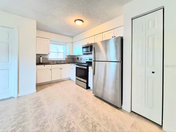 a room with a refrigerator and a sink