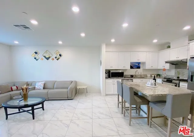 a kitchen with kitchen island granite countertop a sink stove and refrigerator