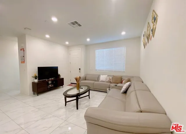 a living room with furniture and kitchen view
