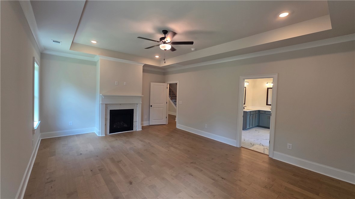 243 Holly Br Road Piedmont, SC 29673 - Photo 14 of 21 Elegant primary bedroom offers a cozy fireplace and rich hardwood flooring.