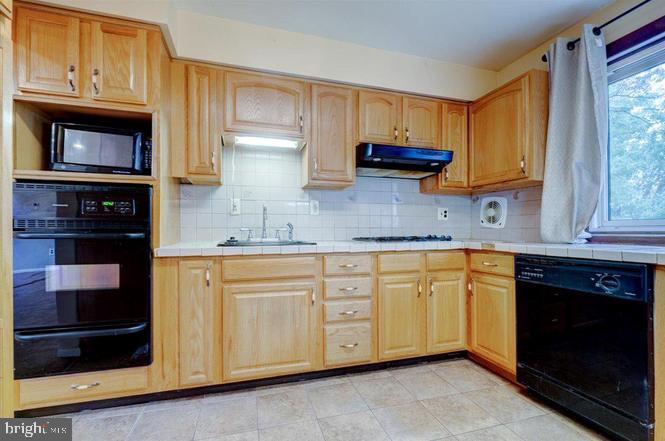 219 Fairview Avenue Lawnside, NJ 08045 - Photo 7 of 21 a kitchen with granite countertop cabinets stainless steel appliances and a window
