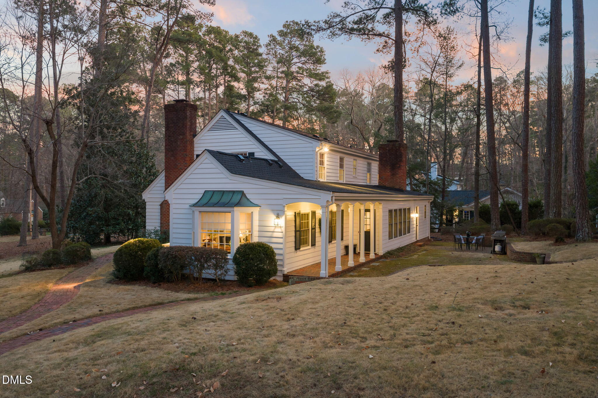 a view of a house with a yard and large trees