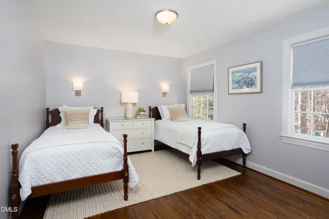 a view of swimming pool with lawn chairs and plants