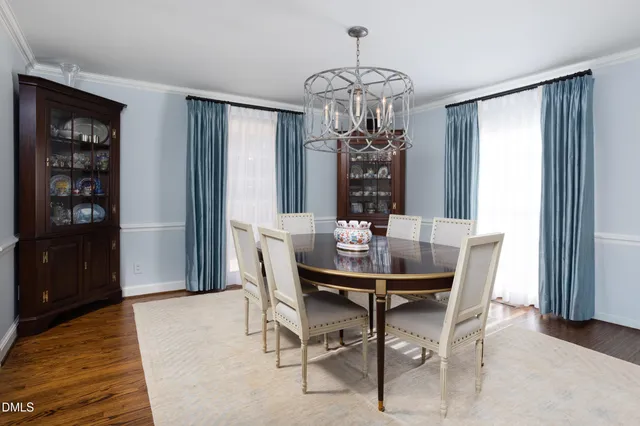 a kitchen with stainless steel appliances granite countertop a table chairs sink refrigerator and cabinets