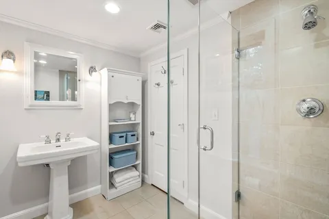 a bathroom with a shower sink and mirror