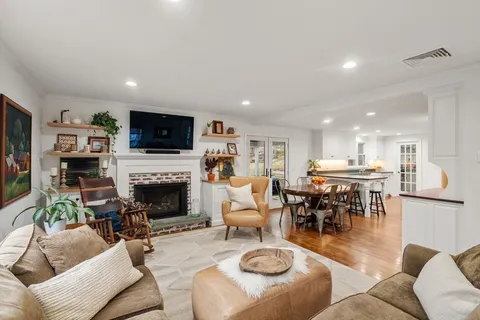 a living room with furniture a fireplace and a flat screen tv