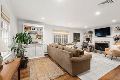 a living room with furniture a flat screen tv and a fireplace