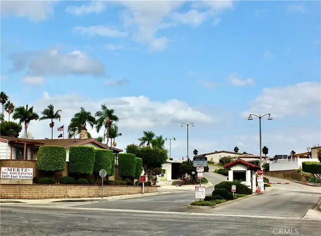 a view of a house with a yard and palm trees