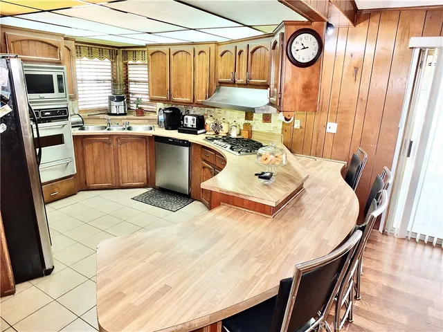 a kitchen with stainless steel appliances a stove a sink and cabinets
