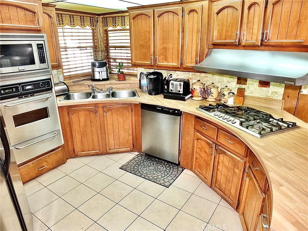 2601 East Victoria Street, Unit 439 Rancho Dominguez, CA 90220 - Photo 22 of 32 a kitchen with stainless steel appliances a stove a sink and cabinets