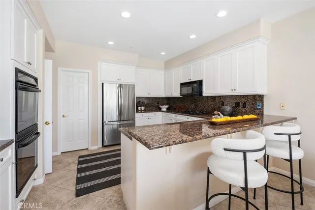 a kitchen with granite countertop a refrigerator sink and cabinets