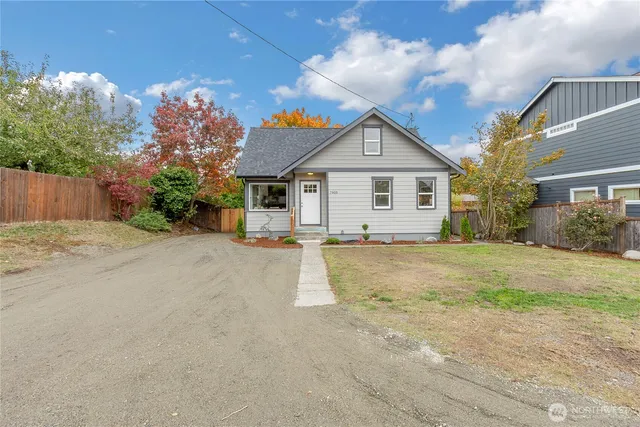 a view of a house with a yard and large tree