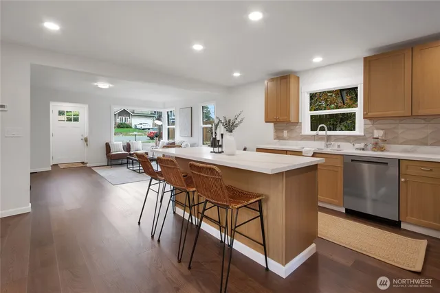 a kitchen with a sink a stove cabinets and wooden floor