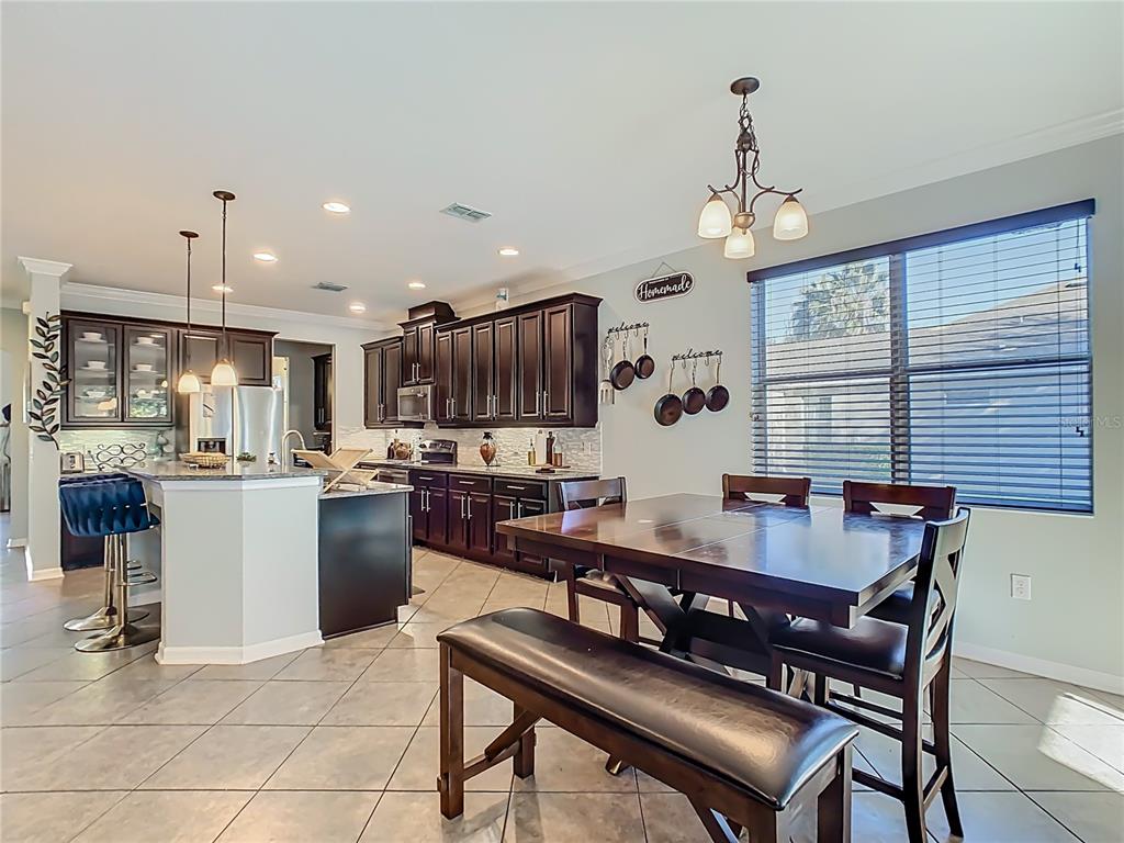 168 Magneta Loop Auburndale, FL 33823 - Photo 14 of 75 a kitchen with a refrigerator a stove a sink dishwasher with a dining table and chairs