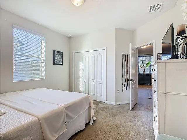 a bedroom with a bed a flat screen tv and a couch