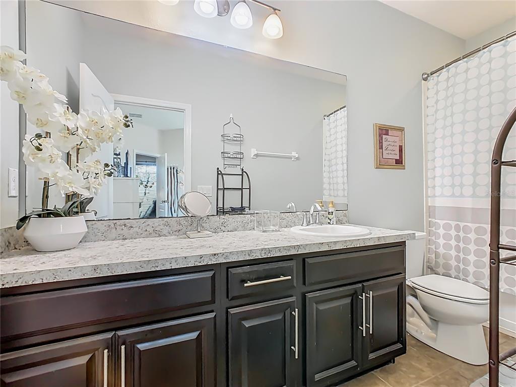 168 Magneta Loop Auburndale, FL 33823 - Photo 30 of 75 a bathroom with a granite countertop sink a toilet and a mirror