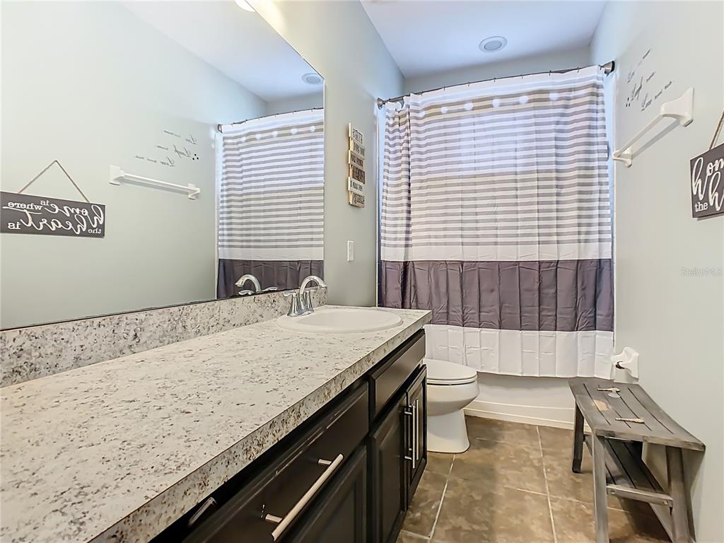 168 Magneta Loop Auburndale, FL 33823 - Photo 33 of 75 a bathroom with a granite countertop sink a toilet a mirror and shower