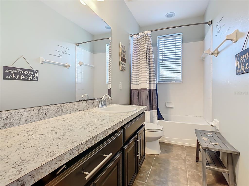 168 Magneta Loop Auburndale, FL 33823 - Photo 34 of 75 a bathroom with a granite countertop sink a toilet a mirror and bathtub