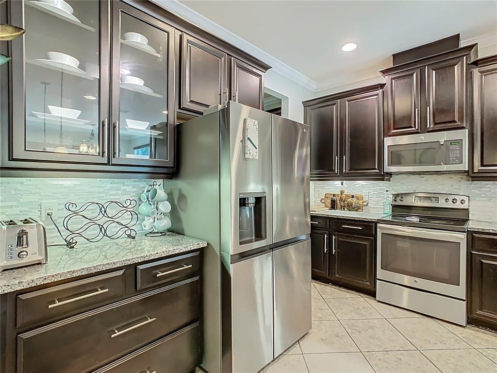 168 Magneta Loop Auburndale, FL 33823 - Photo 6 of 75 a kitchen with granite countertop stainless steel appliances and wooden cabinets