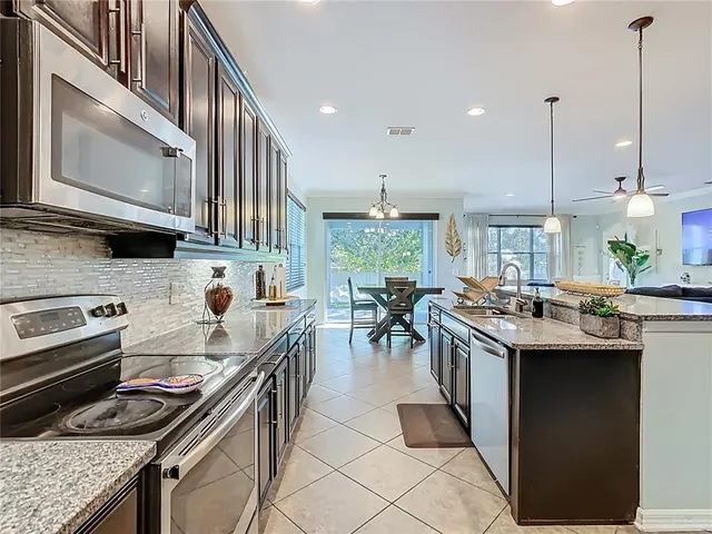 a kitchen with stainless steel appliances granite countertop a stove a sink and a refrigerator