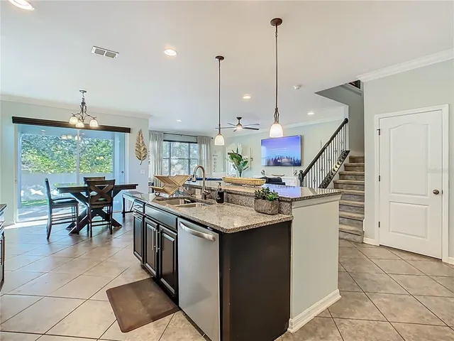 a kitchen with a refrigerator a stove a sink dishwasher with a dining table and chairs