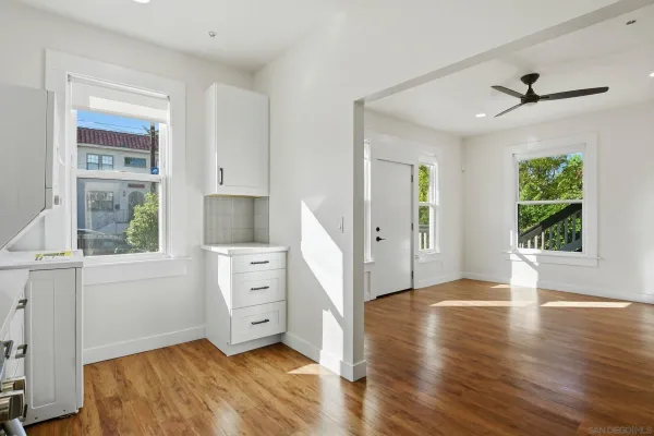 a view of an empty room with a window and wooden floor