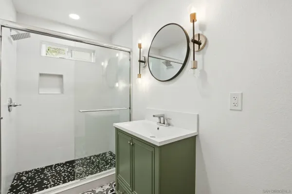 a bathroom with a sink a mirror and a shower