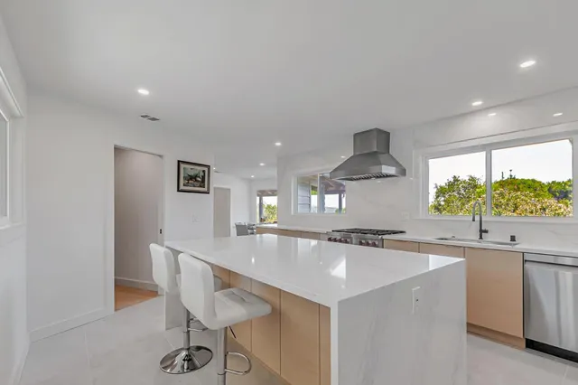 a kitchen with granite countertop a sink and white cabinets
