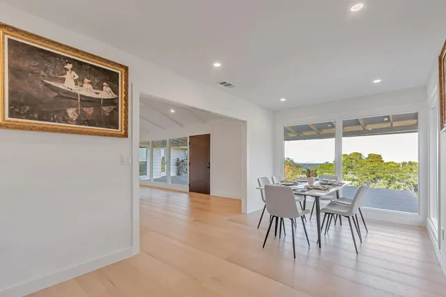a dining room with furniture and a floor to ceiling window
