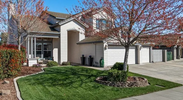 a view of a house with a yard and large tree